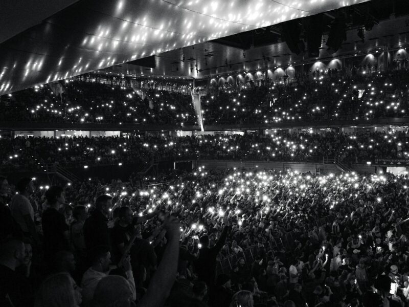 Stadionkonzert mit bunten LED-Armbändern und Lichtshow