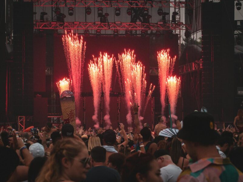 Riesige Festivalmenge bei Sonnenuntergang vor beleuchteter Bühne