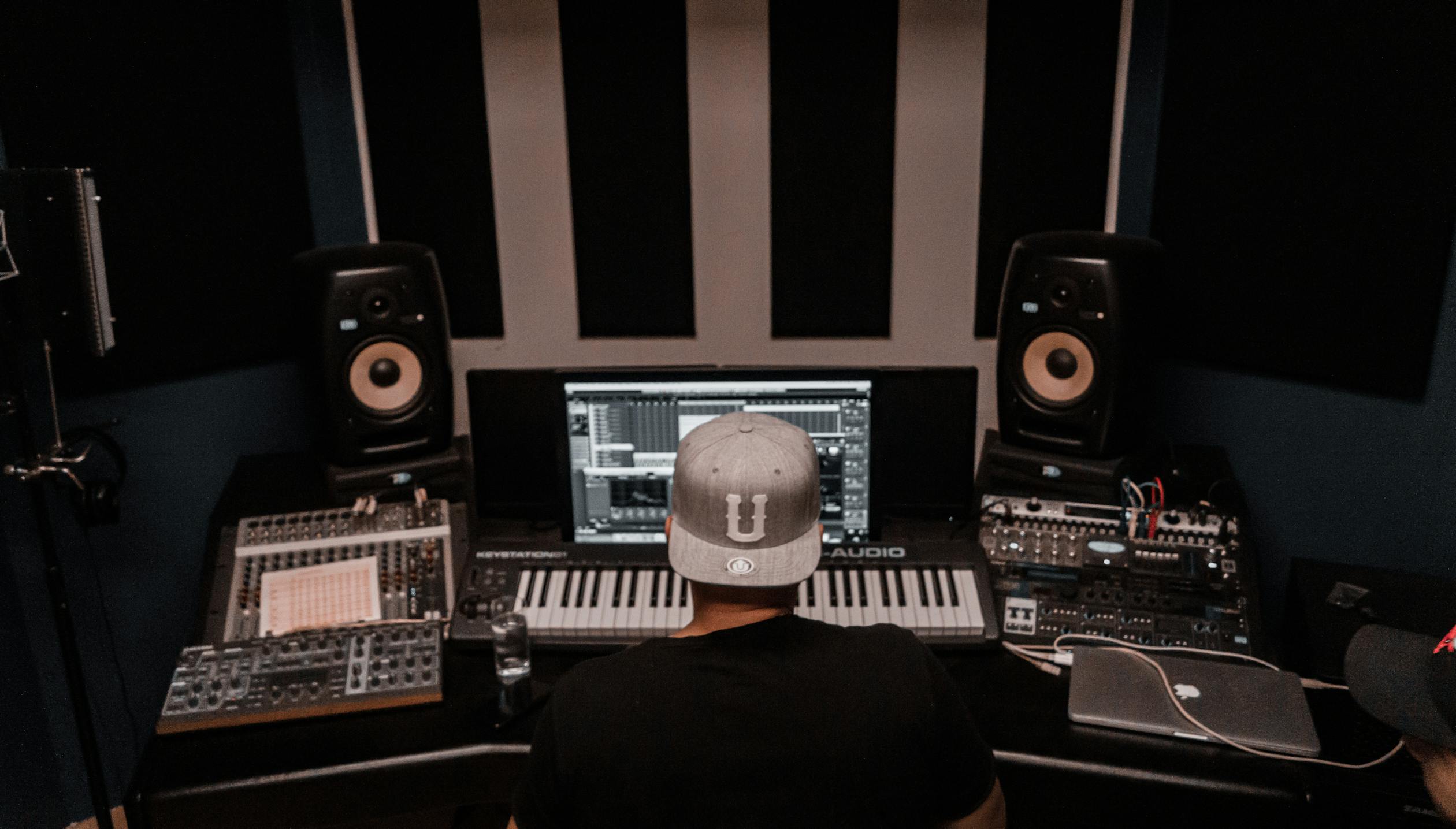 Music producer working in studio with monitors and keyboard