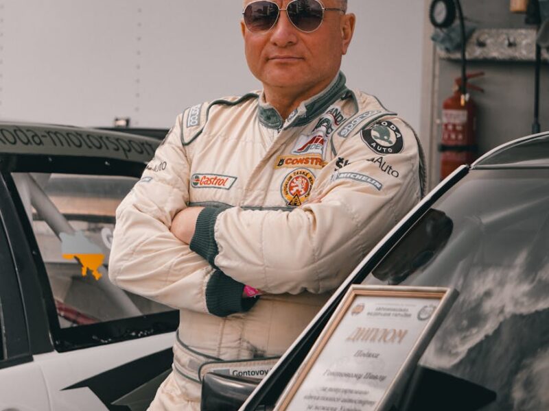 Selbstbewusster Rennfahrer im Cockpit mit Rennanzug