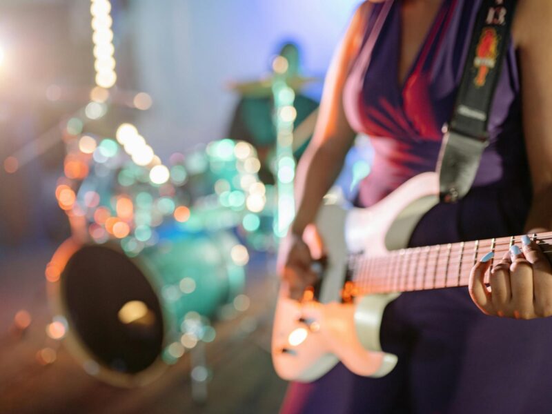 Rockband auf dunkler Bühne mit Gitarren und Strahler