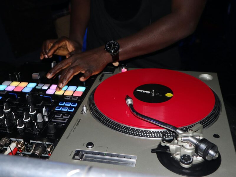 DJ an Plattenspielern in einem beleuchteten Nightclub