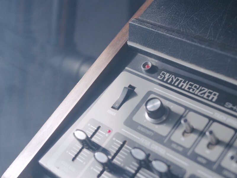 Analoger Synthesizer mit Patchkabeln in dunklem Studio
