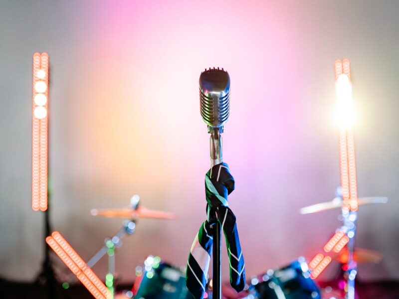 Retro-Mikrofon auf Bühne mit farbigen Konzert-Lichtern