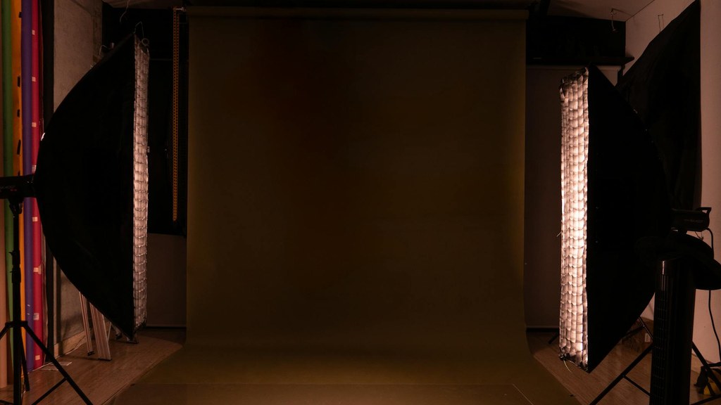 Aufnahme eines Fotostudios mit mehreren Scheinwerfern, Reflektoren und einem Stativ zeigt ein professionelles Beleuchtungssetup.