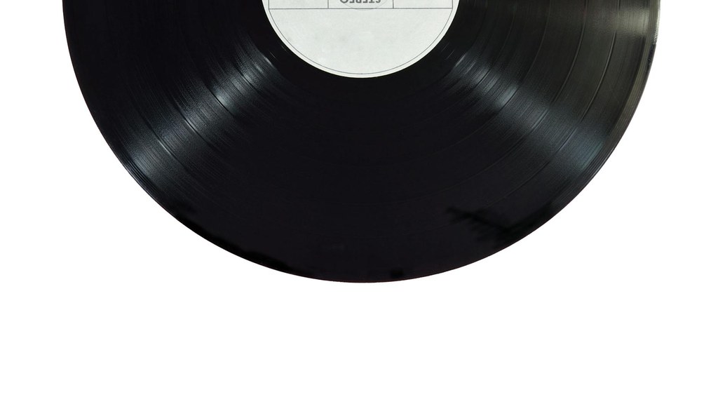 Aufnahme einer schwarzen Schallplatte auf einem Plattenspieler zeigt den glänzenden Vinyl-Lauf.