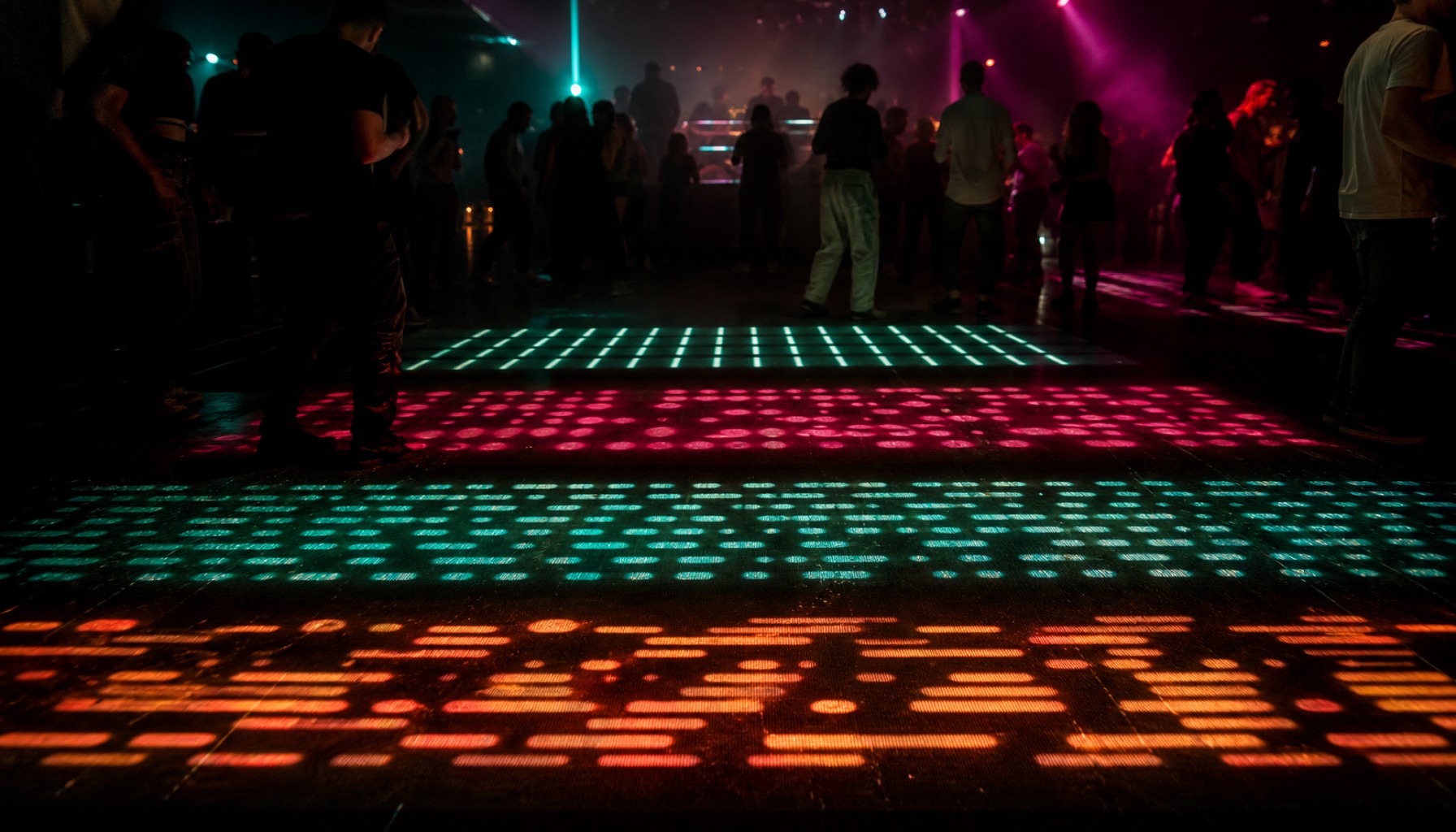 Dunkle Club-Tanzfläche mit leuchtenden roten, türkisfarbenen und orangefarbenen Lichtmustern und Gästen