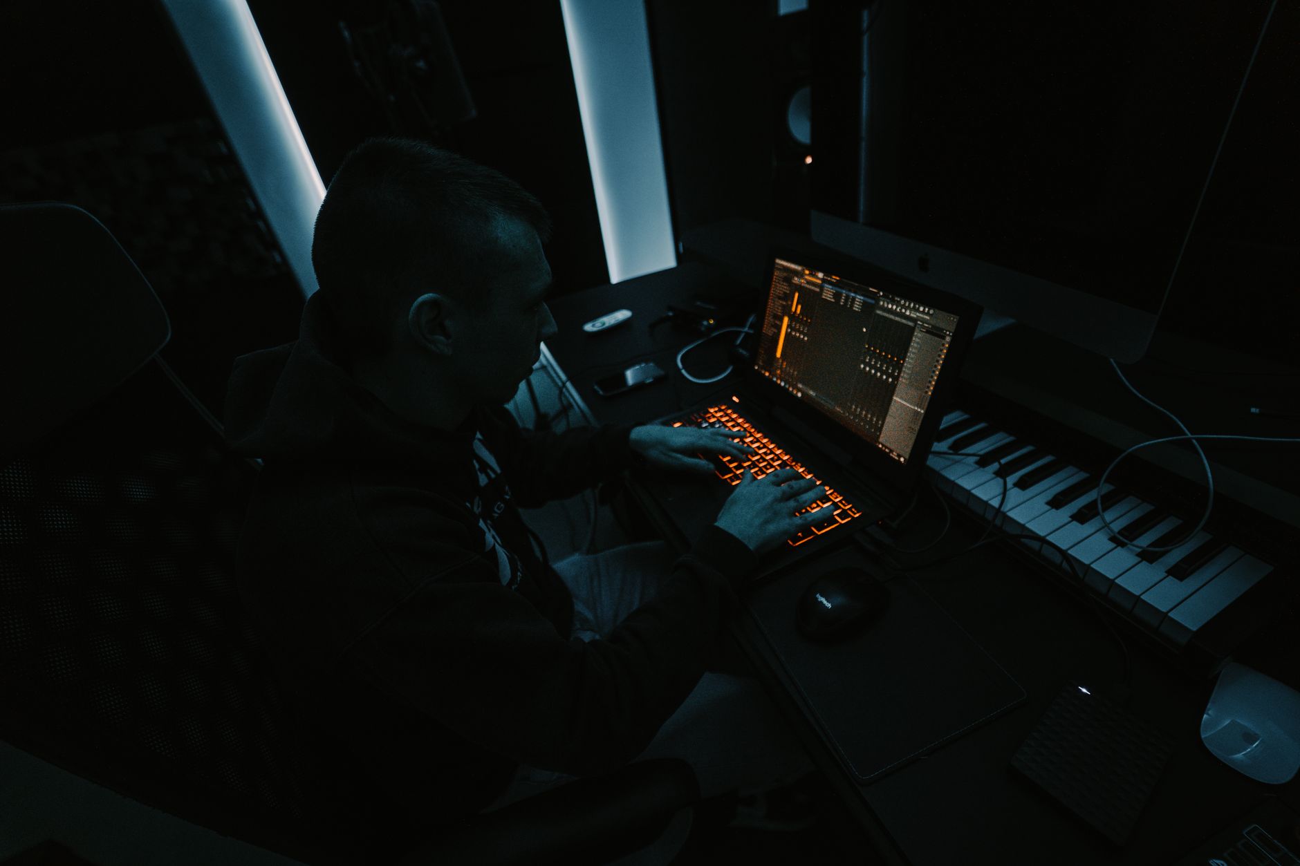 Producer im dunklen Studio an der KI-Musikproduktion